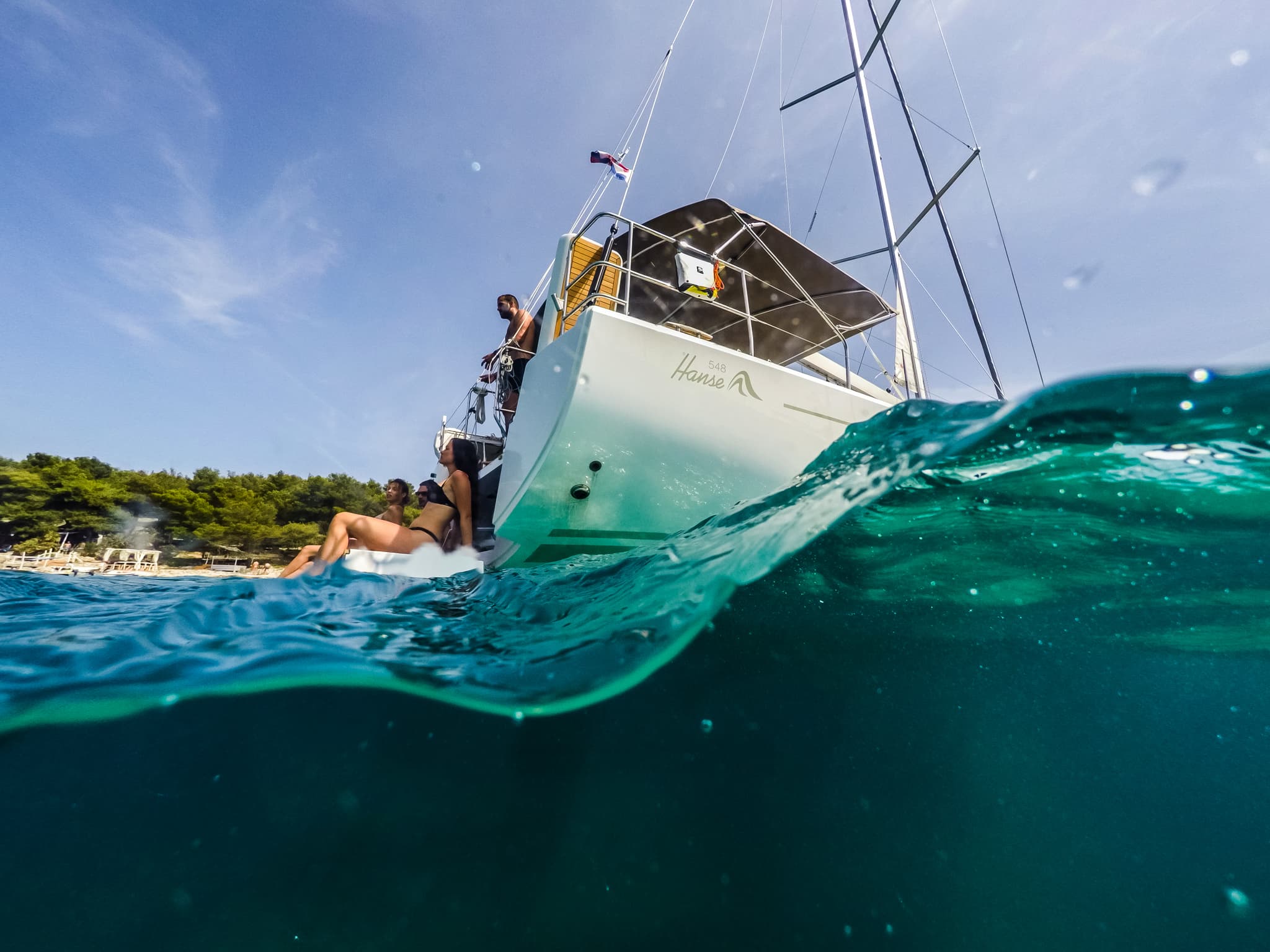 Some people stand on a Hanse sailing yacht deck of an underwater boat angle
